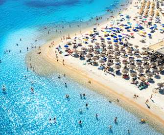 Ein voller Strand mit vielen Sonnenschirmen