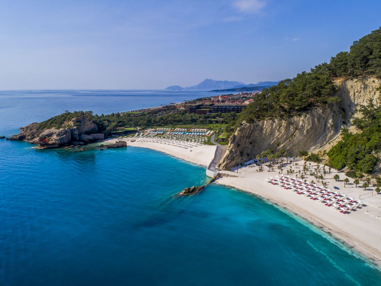 Strandabschnitt mit Felsen, Hotelgebäude und Meerblick im Maxx Royal Kemer Resort an der Türkischen Riviera