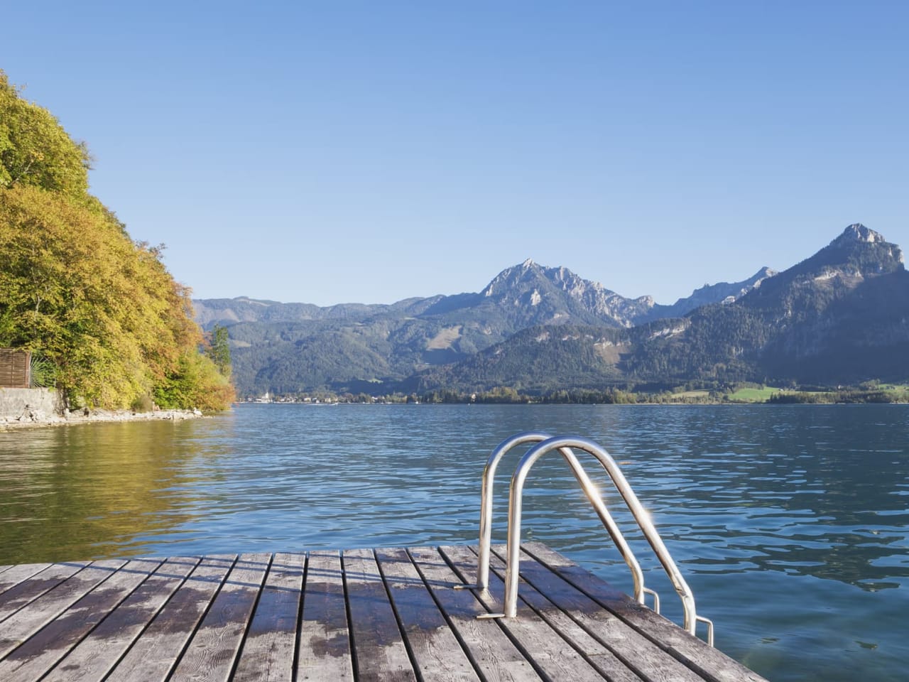 Ein Badesee mit Bergen im Hintergrund im Salzburger Land, Österreich.